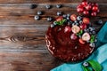 Berry pie on  blue towel, 1 round chocolate homemade cake with fresh blueberries and red grapes, mint on a wooden Royalty Free Stock Photo