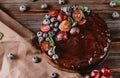 Berry pie close up , homemade chocolate cake with fresh berries red grapes and blueberries, mint on a beige towel on a wooden Royalty Free Stock Photo