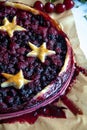 Berry pie with dough stars on a baking paper