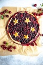 Berry pie with dough stars on a baking paper