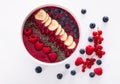 Berry smoothie bowl with chia seeds, bananas, blueberries, currant and raspberries on black white background