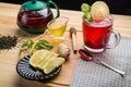 Berry tea in a cup next to lemon, honey, ginger lemon balm and a teapot on the table. Royalty Free Stock Photo