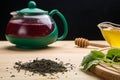 Berry tea in a teapot next to it and lemon and lemon balm and honey Royalty Free Stock Photo