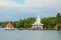 white Buddha figure sits over lake