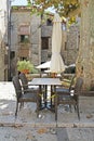 Empty terrace with seats and sunshades from a restaurant in the shade on the background of the old town Besalu Royalty Free Stock Photo