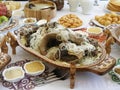 Beshbarmak - Kazakh national dish on a carved wooden platter. Festive table