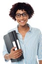 Bespectacled woman in casuals holding files Royalty Free Stock Photo