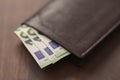 Bespoke brown all leather wallet on walnut table with euro cash