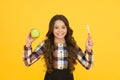 The best care. Little girl smile with fruit and tooth brush. Happy child hold green apple and toothbrush. Keep mouth and