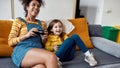 The best care taker. African american woman, baby sitter and little girl having fun together, playing video games Royalty Free Stock Photo