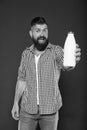 The best drink for your body. Bearded man holding bottle of milk drink on grey background. Happy hipster smiling with Royalty Free Stock Photo