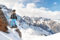 Best epic extreme winter sport photo with young woman snowboarder in funny mohawk hat in rocky mountains