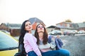 Best female friends cheering by car road trip at sunset. Happy people outdoor on vacation tour