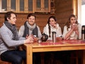 Best friends drinking hot tea in cosy kitchen at winter cottage Royalty Free Stock Photo