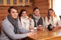 Best friends drinking hot tea in cosy kitchen at winter cottage Royalty Free Stock Photo