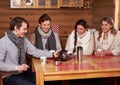 Best friends drinking hot tea in cosy kitchen at winter cottage Royalty Free Stock Photo