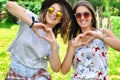 Best friends girls showing heart gesture.