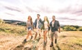 Best friends group walking free on grass meadow - Friendship and freedom concept with young millenial people sharing time Royalty Free Stock Photo