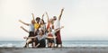 Best friends having fun together at the beach - Group of happy young people with arms up enjoying holiday outside Royalty Free Stock Photo