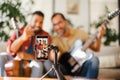 Best friends, musician jamming together, making video on social media. Playing music on guitar together at home for fans Royalty Free Stock Photo