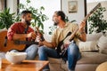 Best friends, musician jamming together. Playing music on guitar together, having beer and fun. Concept of male Royalty Free Stock Photo