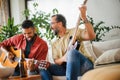 Best friends, musician jamming together. Playing music on guitar together, having beer and fun. Concept of male Royalty Free Stock Photo