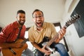 Best friends, musician jamming together. Playing music on guitar together, having fun. Concept of male friendship Royalty Free Stock Photo