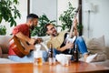 Best friends, musician jamming together. Playing music on guitar together, having beer and fun. Concept of male Royalty Free Stock Photo