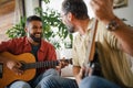 Best friends, musician jamming together. Playing music on guitar together, having fun. Concept of male friendship