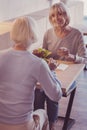 Satisfied aged woman spending time with girlfriend and smiling.