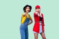 Best friends spending great time together. Two beautiful amazed fashionable hipster girls standing and pointing finger to you, Royalty Free Stock Photo