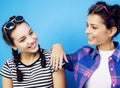 Best friends teenage school girls together having fun, posing emotional on blue background, besties happy smiling