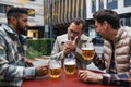 Best friends togehter, drinking beer and talking in bar in city. Concept of male friendship, bromance. Royalty Free Stock Photo