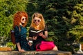 Best girlfriends are reading book in park.