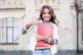 The best lesson ever. Happy little child giving thumbs up for literature lesson. Small girl smiling with lesson books Royalty Free Stock Photo