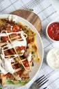 Baked potato with greens, garlic and sauces on a white plate Royalty Free Stock Photo