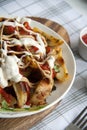 Baked potato with greens, garlic and sauces on a white plate Royalty Free Stock Photo