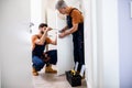 Best men at work. Full length shot of two locksmith, repairmen, workers in uniform installing, working with house door Royalty Free Stock Photo