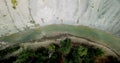 Top down aerial view of the folowing dron along the wilderness, the rivers along the cliff