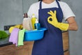 Best products. Cropped shot of cleaning lady showing ok sign while holding container full of cleaning products and