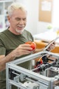 Upbeat senior engineer being content with printed model