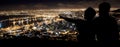 The best seat in the house. Silhouette of a young couple enjoying the city nightscape.