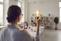 Best teacher with idea light bulb inspires elementary children at lesson