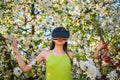 The best virtual reality. Cute girl play in spring garden. Young lady wear vr glasses on spring nature. Pretty girl in