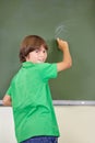 The best way to learn. A young boy writing on the blackboard at school. Royalty Free Stock Photo