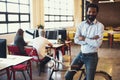 The best way to move around the office. a handsome man on a bicycle in a modern office. Royalty Free Stock Photo