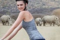 The best way to view wildlife. Portrait of a young woman on a bicycle looking at a group of rhinos in the veld.