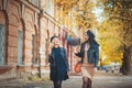 Best weather ever! Outdoors shot of young women with coffee on city street. Two fashion girls walking outdoor with cofee. Royalty Free Stock Photo