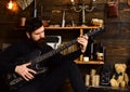 Best weekend. Man bearded musician enjoy evening with bass guitar, wooden background. Man with beard holds black