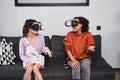 Besties sitting at sofa and using virtual reality headset